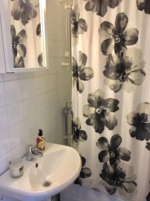 Ljust vardagsrum med soffa och konst i lägenhet på Södermalm; Stort sovrum med dubbelsäng på Södermalm; Enkelt sovrum på Södermalm; Ytterligare enkelt sovrum på Södermalm; Utrustat kök med spis och kyl på Södermalm; Privat terrass på lugn gata i Södermalm