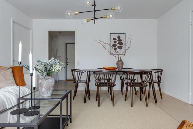 Living room with dining table and sofa bed in Södermalm apartment.