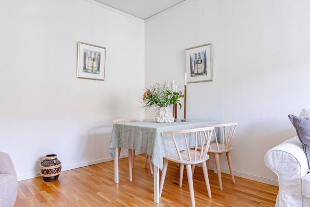 Living room with sofa bed and dining table in a cozy Globen apartment.