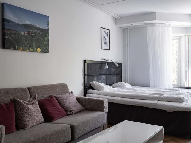 Studiovardagsrum i Stockholm med stora fönster och mysig sittgrupp
