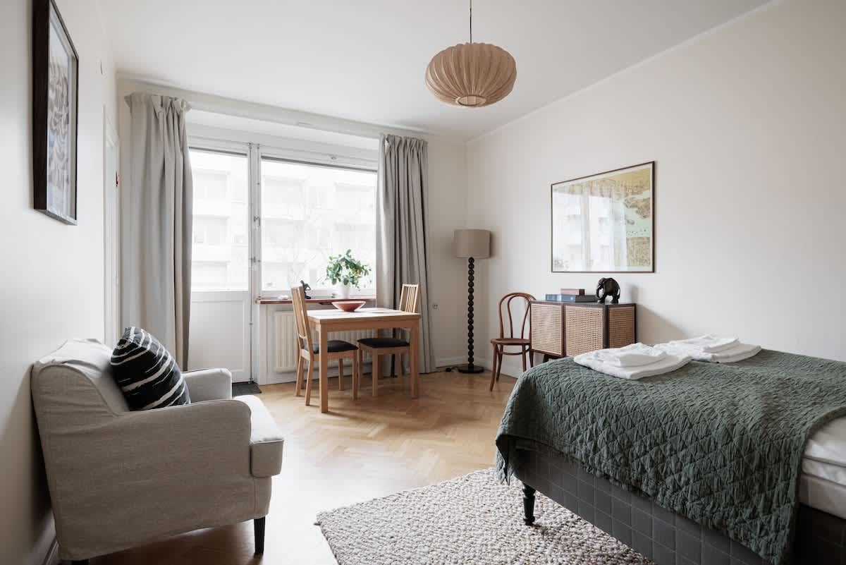 Stockholm studiolägenhet, 140 cm säng, matbord för två, kompakt kök, fåtölj, hall